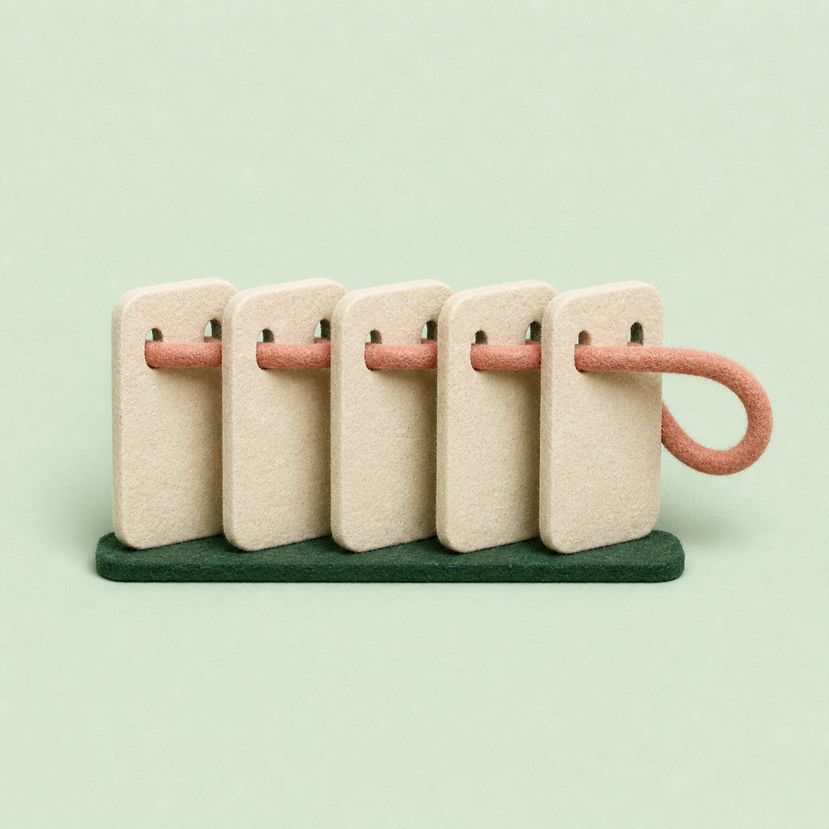 Five cream felt panels connected by one continuous muted-coral thread